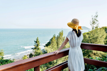 Wall Mural - Young woman enjoying sea view  in balcony.