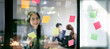 © NAMPIX - Young confident Businesswoman planning with adhesive notes in creative office.