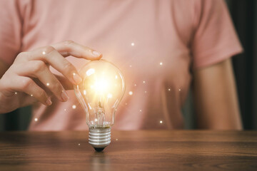 Poster - Bright light bulb in hand, idea search concept, creativity