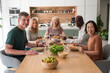© PhotoAlto - Group of diverse senior friends gathered together for lunch in the kitchen