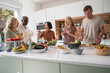© PhotoAlto - Middle-aged diverse friends having a good time in the kitchen while preparing dinner