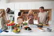 © PhotoAlto - Group of senior diverse friends gathered around kitchen island while preparing meal