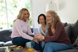 © PhotoAlto - Portrait of three senior ladies having a good time together watching photos on mobile phone at home