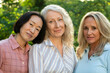 © PhotoAlto - Group of three middle-aged women posing for photo in backyard