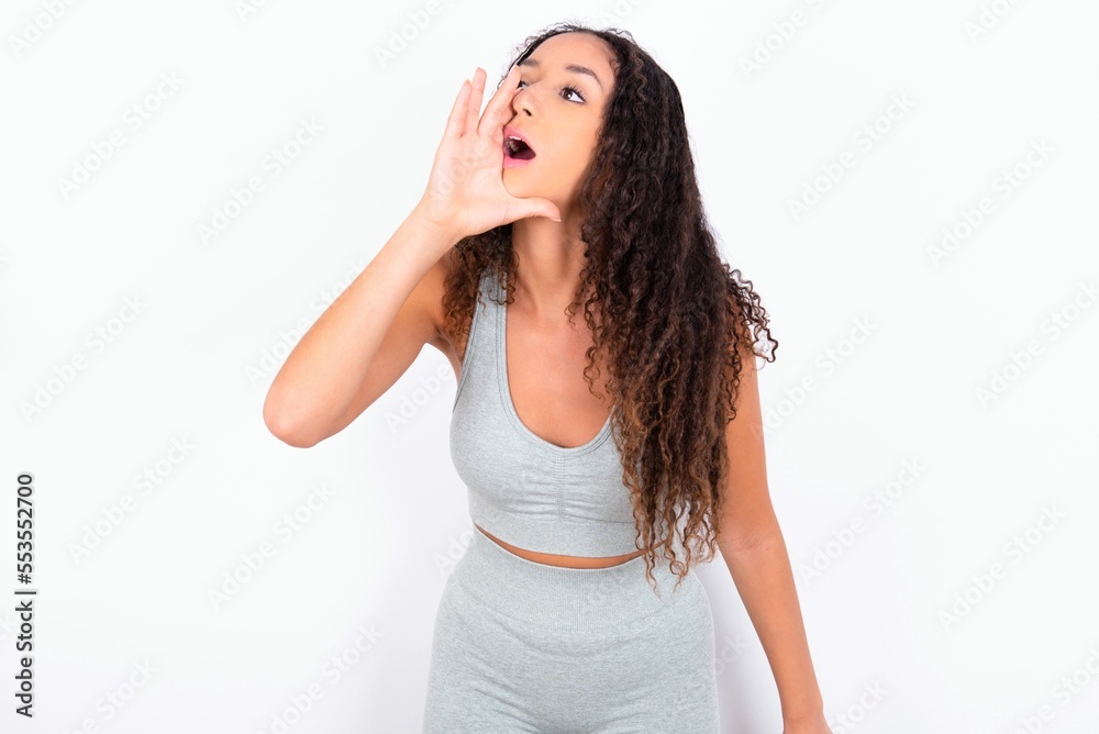 Beautiful teen girl with curly hair wearing grey sport set over white ...