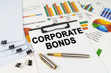 Wall Mural - On the table among financial graphs and charts lies a tablet with the inscription - Corporate Bonds