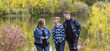 © Designpics - A young man with Down Syndrome walking with his father and mother while enjoying each other's company in a city park on a warm fall evening; Edmonton, Alberta, Canada