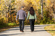 © Designpics - A mature married couple walking together and holding hands in a park during the fall season; St. Albert, Alberta, Canada
