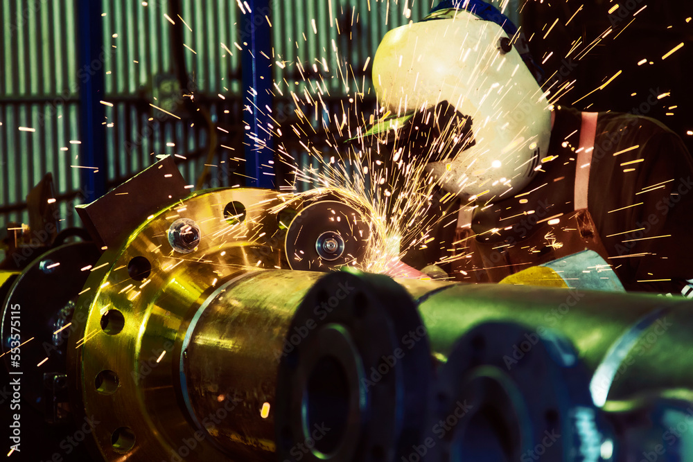 Machine Fitter A journeyman pipe fitter welder grinding a flange butt weld on a ...