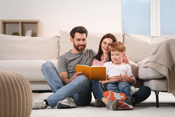 Sticker - Happy parents with their child reading book on floor at home