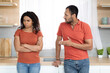 © Prostock-studio - Sad angry young black husband swears at wife, offended sad woman in red t-shirt ignores husband after quarrel