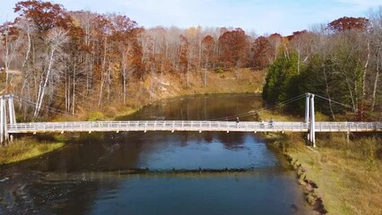 Wall Mural - Late fall vibes aerial at suspension bridge over river in Michigan aerial right over bridge