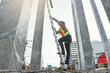 © Chanchai - Side view of worker engineer in safety helmet climbing the ladder to get to the top . worker engineer metal roofing work for roof.