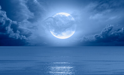 Fotomurales - Night sky with blue moon in the clouds over the calm blue sea 