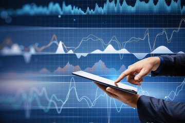 Aufkleber - Close up of businessman hand using tablet with digital business graph hologram on blurry blue background. Trade, finance and analysis concept.