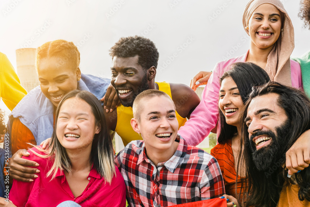 Diverse multi ethnic group of people having fun outdoors - non binary person, gender freedom -