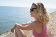 © auremar - woman sat on wall looking at over the sea