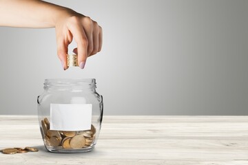 Wall Mural - Golden coins in jar on wooden desk