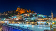 Evening view to Berat, historic city in the south of Albania at night with all lights flashing and white houses gathering on a hill. Captured during blue hour with the sky full of stars.
