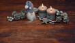 Weihnachtsdekoration: Graue Kerzen mit Weihnachtschmuck und Wichtel auf altem Holz.Mit Platz für Text.