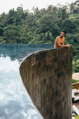 Wall Mural - Young man relaxing in pool at holiday resort