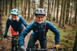 © Flamingo Images - Smiling woman mountain biking with her mom in a forest