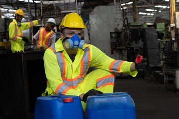 worker wearing uniform protection chemicals.Industrial worker holding plastic bottle with chemicals in factory.