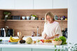 © PhotoAlto - Attratctive middle age woman cutting fruit in her kitchen