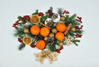 Festive Christmas border from conifer tree branches ,wooden bells , fresh viburnum berries, tangerines, gold nuts ,cones, rattan  handmade snowballs on white background. Top view .Free copy space