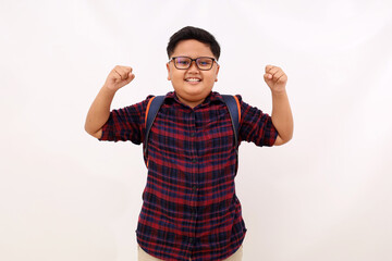 Wall Mural - Successful asian school boy standing with clenched hands. Isolated on white background