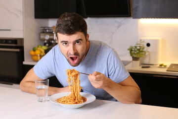 Man enjoying a plate of spaghetti with tomato sauce 