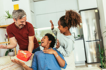 Father and daughter congratulate mother on holiday and give gift box