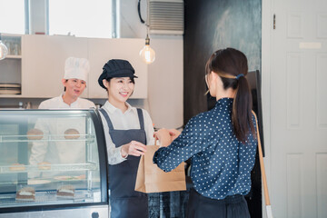 Poster - こだわりのお店でテイクアウトをする若い女性