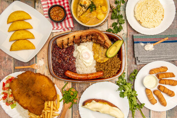 Still life of typical Colombian and Venezuelan recipes, bandeja paisa, corn empanadas, chicken clade, arepas and tequeños and escalope with fried potatoes