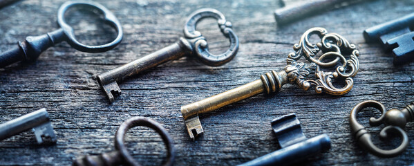Fototapete - Old door keys lying on the table. Choose the right key. Concept on the topic of security, choice, search, etc. Retro style.