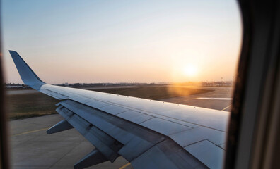 Canvas Print - View on sunset and airplane wing from the inside