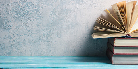 Wall Mural - Composition with vintage old hardback books, diary, fanned pages on wooden deck table and red background. Books stacking. Back to school. Copy Space. Education background.	