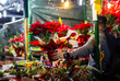 person sells traditional red flowers poinsettias on the Barcelona Christmas market in the evening