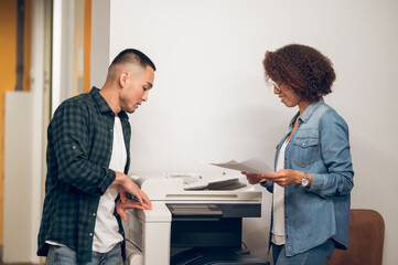 Assistant making document copies for her boss using the photocopier