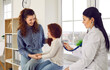 © Studio Romantic - Attractive joyful Caucasian woman with daughter visits family doctor and holds child hand, pediatrician listens to girl heartbeat with stethoscope sits on hospital couch in front of window