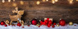 Fröhliche Weihnachten, Panorama, Banner. Hintergrund mit Holz, Schnee, Geschenk, Elch, Bokeh Lichtern.  Weihnachtsdekoration, Weihnachtsmotiv mit Textraum als Grußkarte, Weihnachtskarte, Neujahrsgruß