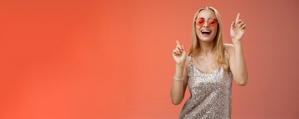 Amused attractive happy smiling woman dancing nightclub having fun enjoying go wild party celebrating b-day wearing stylish dress sunglasses raise index fingers smiling singing along