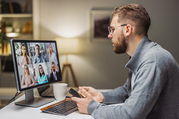 Young man on videochat with colleagues, having remote employment, discussing business.