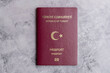 Turkish passport on marble background. Isolated close-up Turkish passport. Travel documents and passports. Visa papers and documents. Immigration and refugee. Obtaining Turkish citizenship.