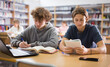 © JackF - Portrait of two focused schoolchildren doing homework in the school library, sitting at a desk in front of a laptop