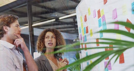 Poster - Composite video of office ceiling against caucasian man and woman discussing over memo notes