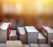 Stack of books in library and blurred bookshelf background and the golden light shines for education and learning into the future