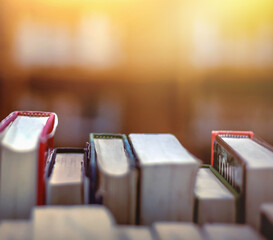 Poster - Stack of books in library and blurred bookshelf background and the golden light shines for education and learning into the future
