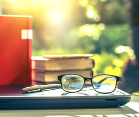 Poster - Stack of books in library and blurred bookshelf background and the golden light shines for education and learning into the future