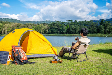 young asian traveling man relax and enjoy outdoor lifestyle camping in forest mountain on summer hol